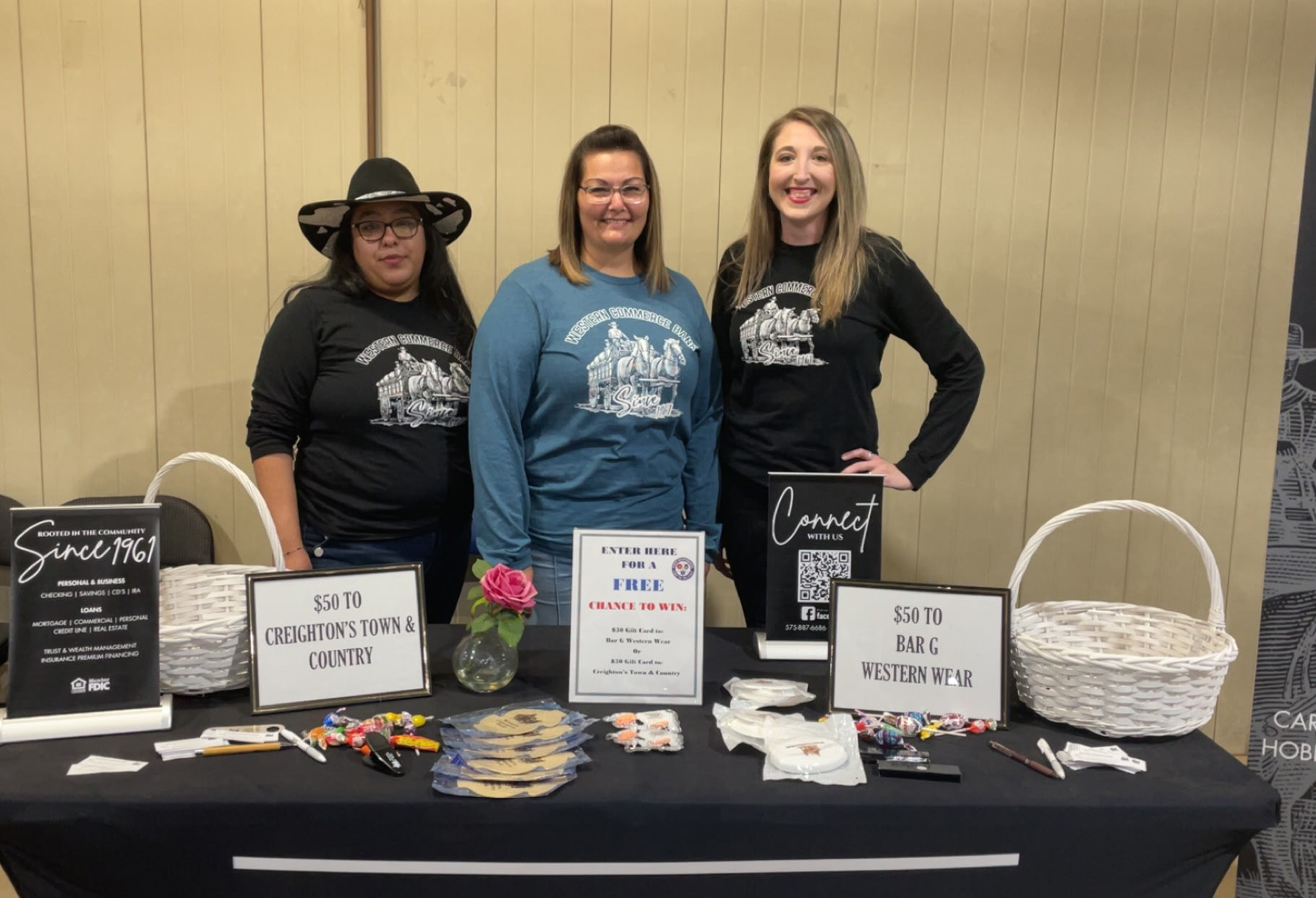 3 bank employees standing behind a giveaway table